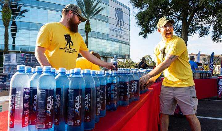 Volunteers at Jacksonville's WWP Carry Forward 5K handing out AQUAhydrate water bottles to participants.