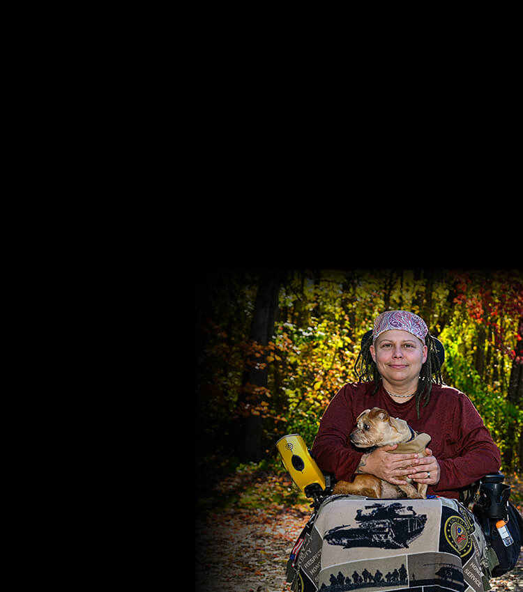 Wounded warrior Angie Lupe in a wheelchair holding a dog