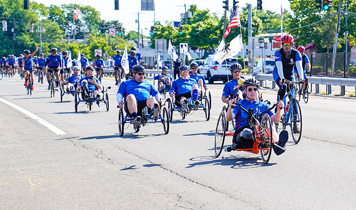 Wounded warriors ride together on various types of bikes, wearing WWP riding gear, with a smile and determination.