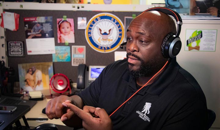 A Wounded Warrior Project team member sitting at his desk, wearing a headset, and speaking with a warrior enrolled in the WWP Talk program.