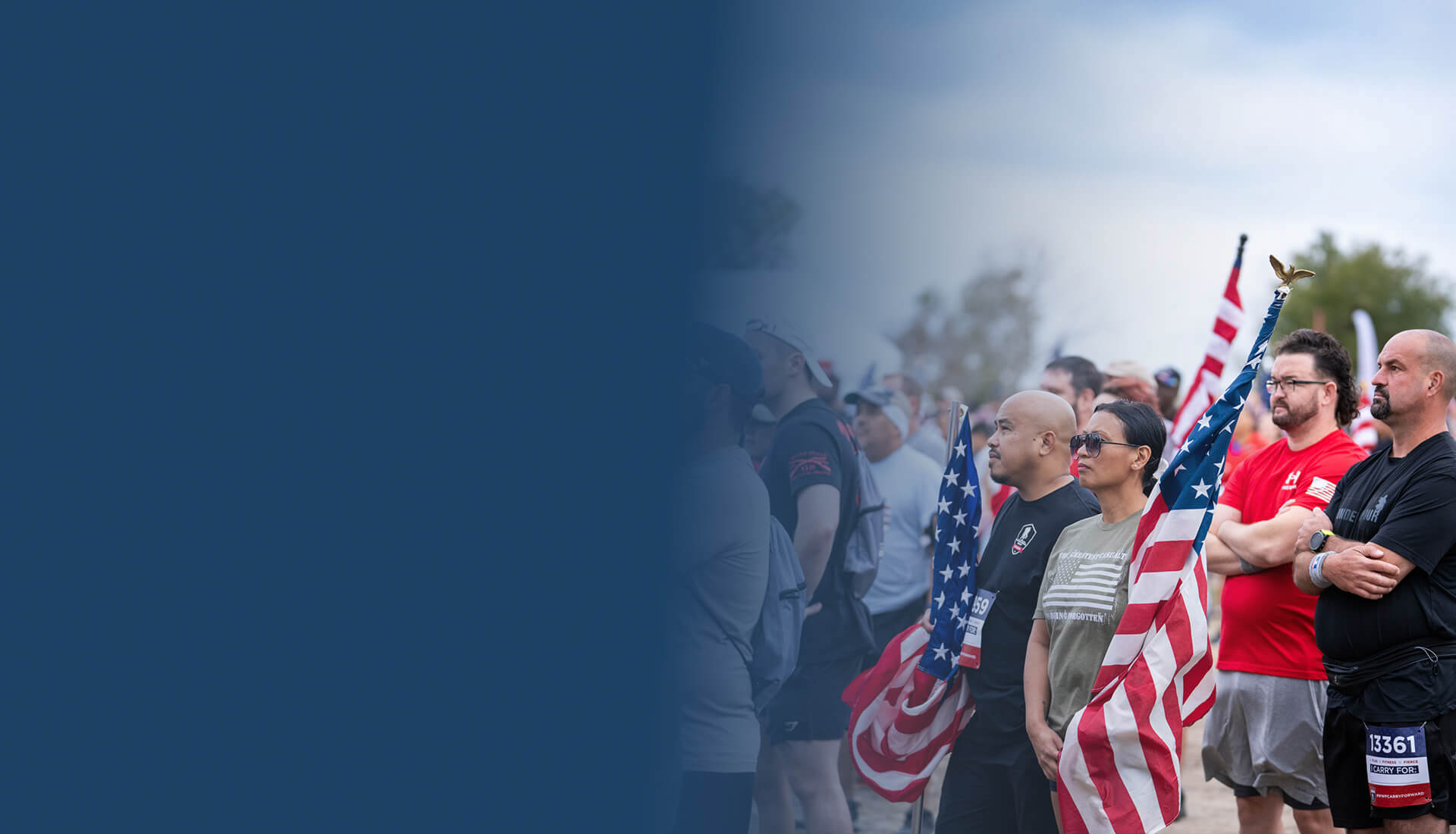 Crowd of people standing with the American Flag.