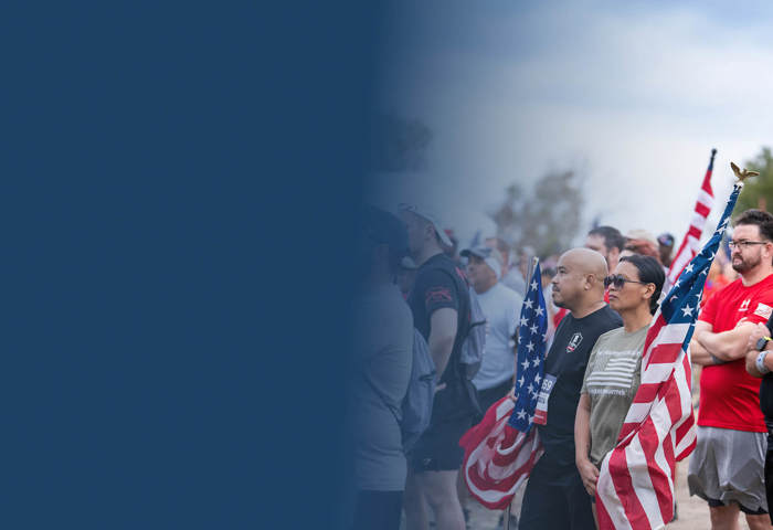 Crowd of people standing with the American Flag.