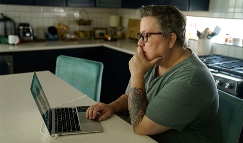 Wounded Warrior Carla Best Sits In Her Kitchen Using Her Laptop